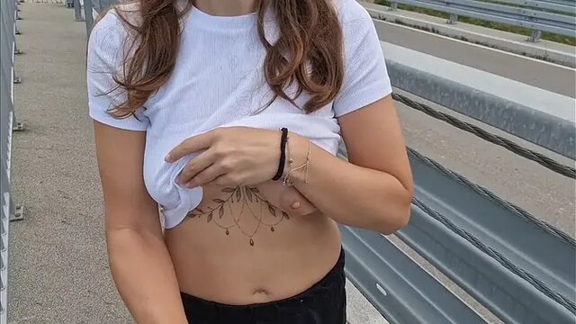 Naughty girl flashes her big boobs on the highway bridge