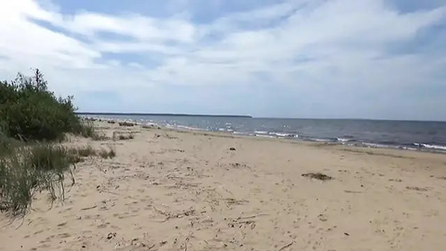 Sexy milf sunbathing in a white bikini by the ocean