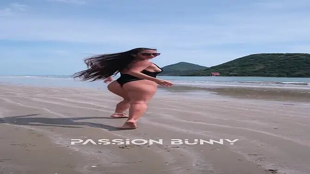 Afrosensual babe in black bikini flashes hot body on sunny beach