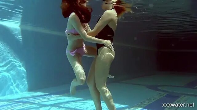 In the indoor pool, two stunning girls swim