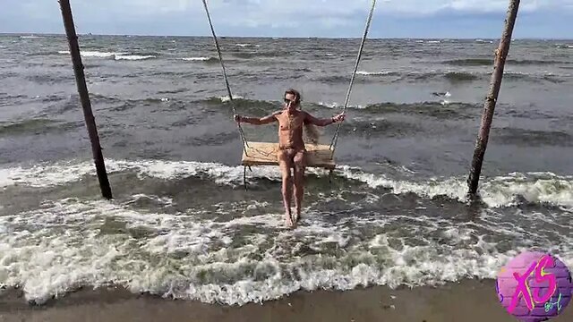 Nude blonde MILF struts on public beach